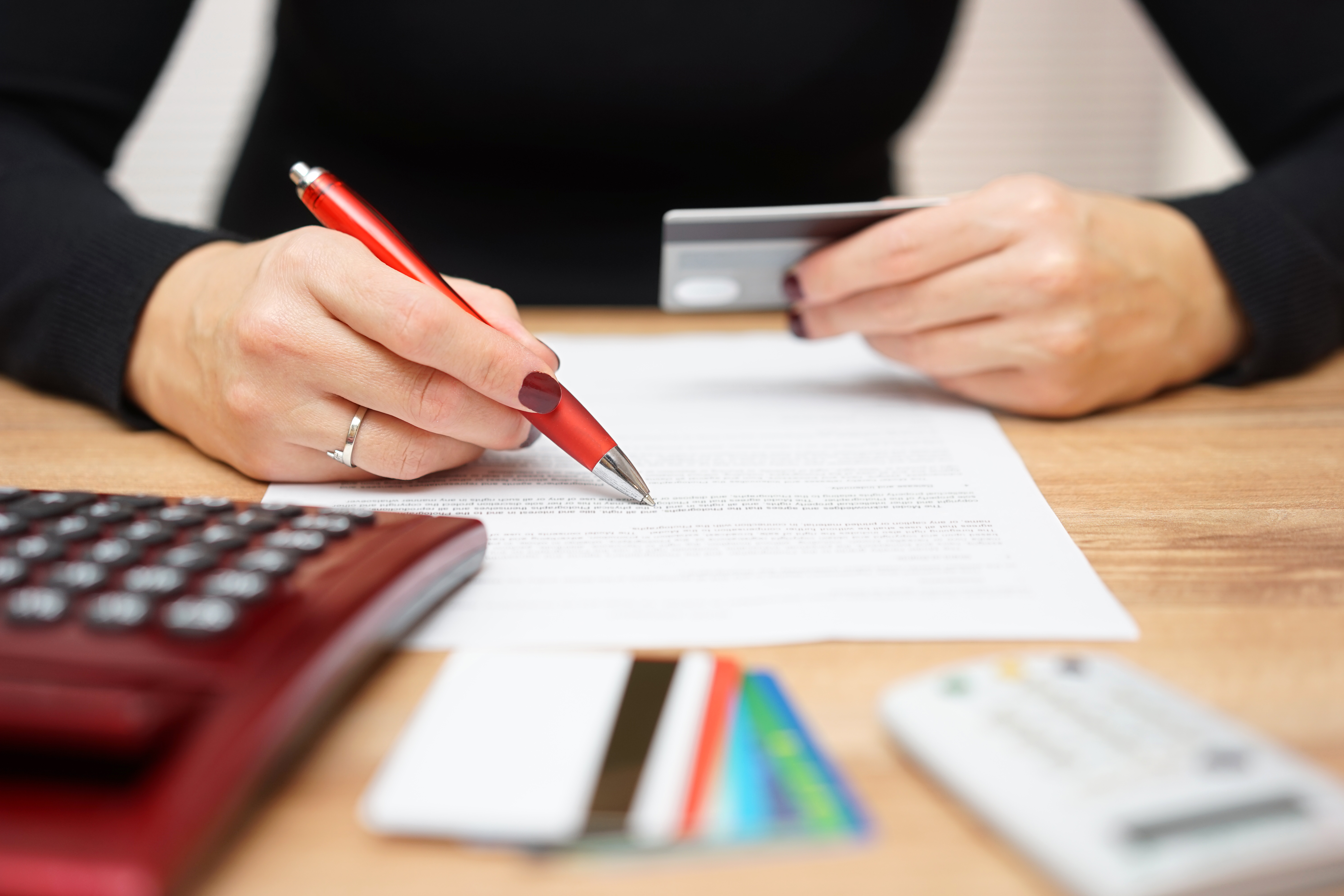 A person holding a paper and a bank card.